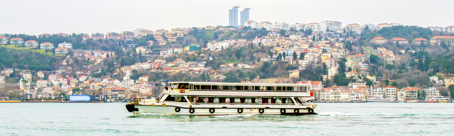A large boat is in the water with a Istanbul city in the background